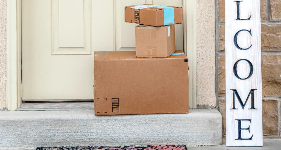 Boxes by the door of a residence with a welcome sign in Denver